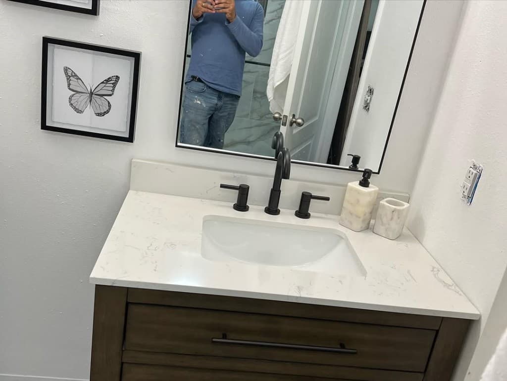 Bathroom remodel dark shaker vanity quartz counter black faucets tall mirror tiled shower doorway reflection craftsman.