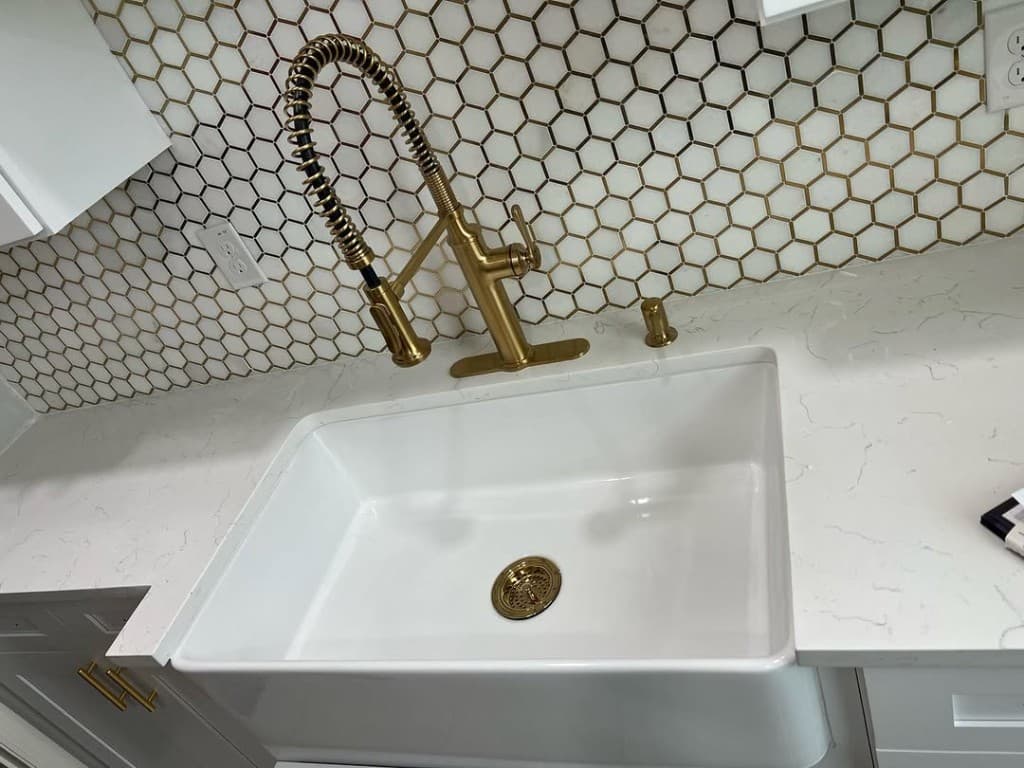 Macro farmhouse sink brushed gold coil faucet hex tile backsplash brushed gold cabinetry hardware soap dispenser satin.